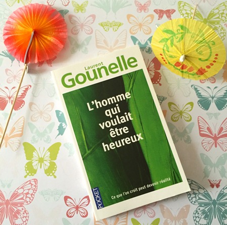 Livre de Laurent Gounelle, "L'homme qui voulait être heureux" posé sur un joli fond imprimé de papillons de couleurs