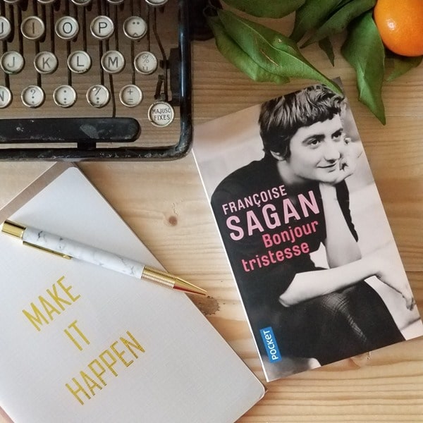 Bonjour Tristesse - Françoise Sagan - roman culte Le roman bonjour "Tristesse" de Françoise Sagan posé sur une table aux côtés d'une vieille machine à écrire