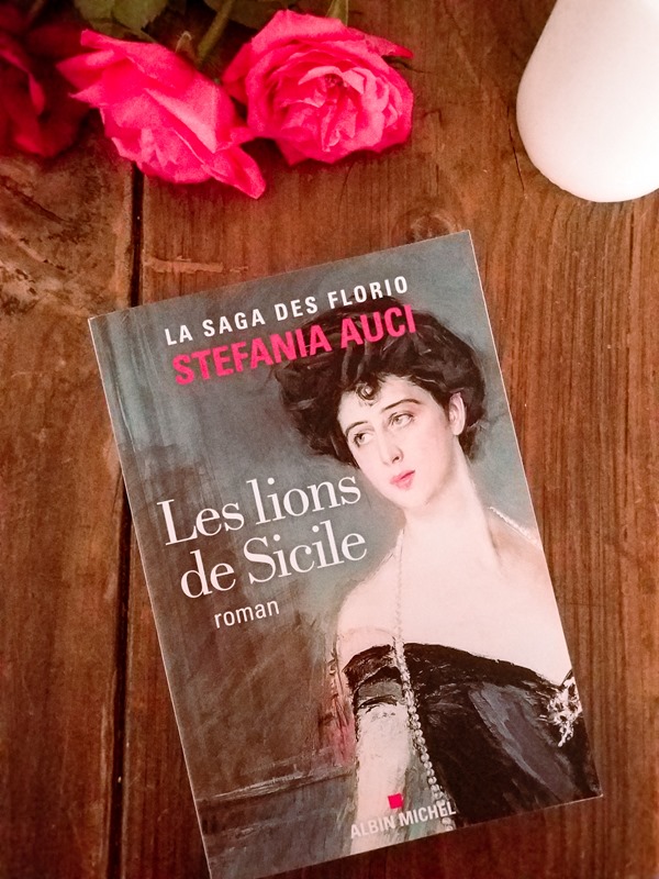 Stefania Auci - les lions de Sicile Le livre de Stefania Auci "Les lions de Sicile" tome 1 posé sur une table avec des roses