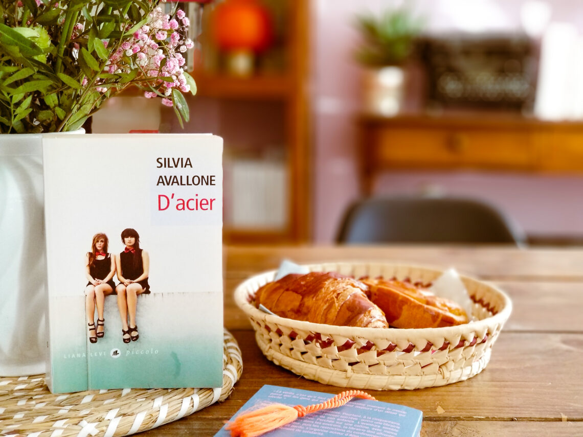 Livre de Silvia Avallone posé sur une table avec des croissants et des fleurs