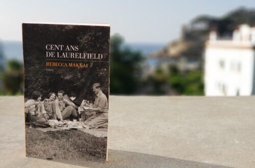 Livre "Cent ans de Laurelfield" de Rebecca Makkai posé sur le rebord du balcon surplombant la mer