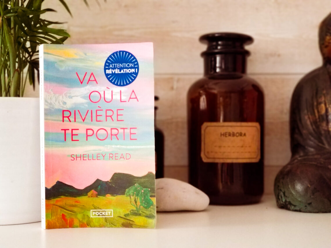 Photo du livre "Va où la rivière te porte" de Shelley Read avec une plante en arrière plan, un flacon d'herboristerie et un bouddha
