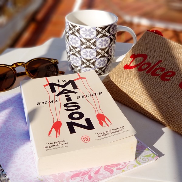 "La maison" de Emma Becker, roman posé sur une table avec le café au soleil pendant les vacances